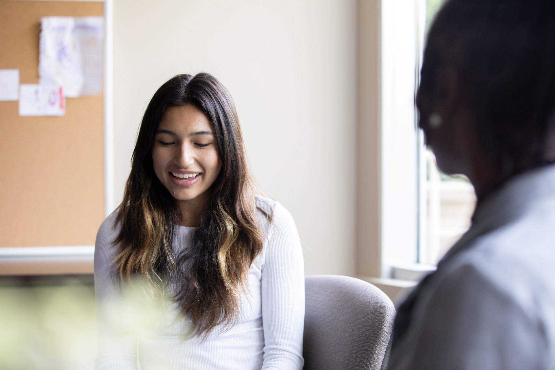 Beautiful teenage high school student meets with teacher or guidance counselor